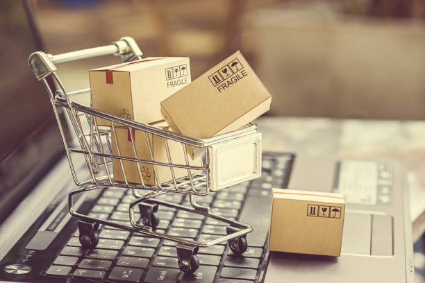 Paper boxes in a shopping cart. Paper boxes in a shopping cart on a laptop keyboard. Ideas about e-commerce, e-commerce or electronic commerce is a transaction of buying or selling goods or services online over the internet. market vendor photos stock pictures, royalty-free photos & images