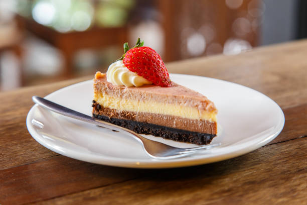 istock Slice of multi layer cheese cake with strawberry on the wooden table 675665316