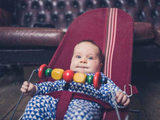 A joyful moment with the baby holding two colorful balls. Her excitement and curiosity fill the room as she enjoys her playful time, surrounded by a cozy home environment.