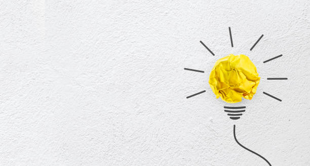 Ideas with yellow paper crumpled ball on wall( lightbulb ).