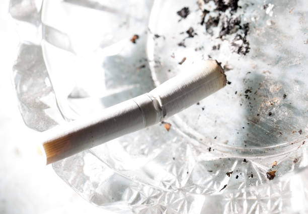 A white cigarette lies in an ashtray .