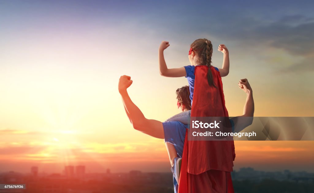 Dad and his daughter playing outdoors Happy loving family. Dad and his daughter playing outdoors. Daddy and child girl in an Superhero's costumes. Concept of Father's day. Father Stock Photo