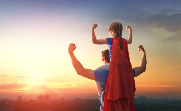 Dad and his daughter playing outdoors Happy loving family. Dad and his daughter playing outdoors. Daddy and child girl in an Superhero's costumes. Concept of Father's day. heroes photos stock pictures, royalty-free photos & images