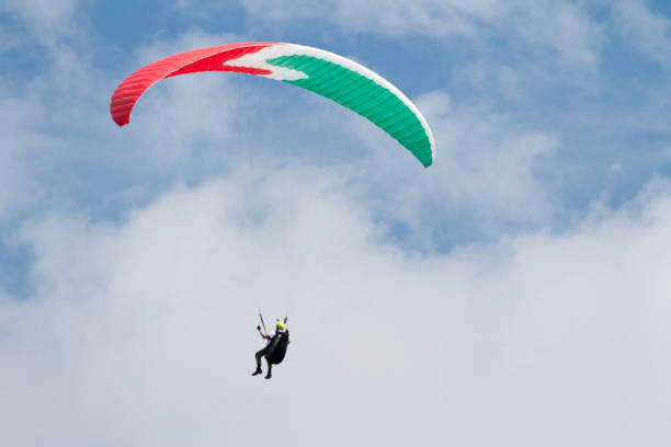 istock A para-glider up in the sky during a fly, with the campaign below him as background 675677490