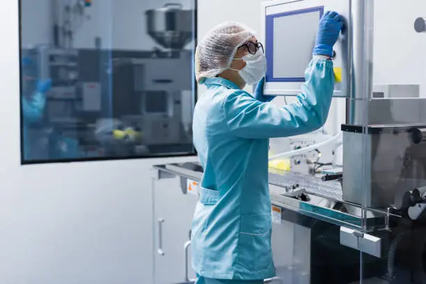 Photo of factory worker configures control panel