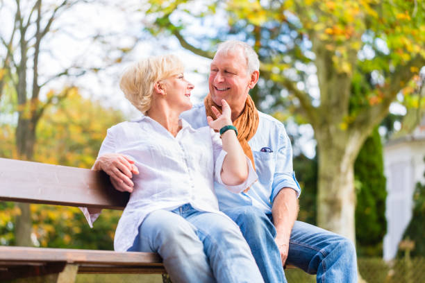 istock Senior couple sitting on part bench in fall 675684950