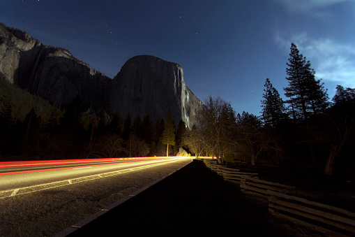 El Capitan in Yosemite lit by moonlight and passing car