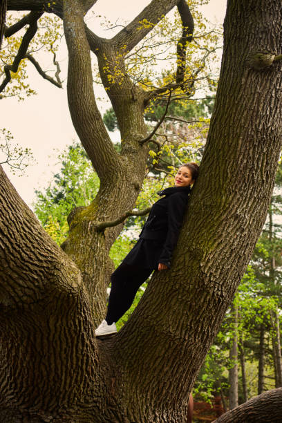 istock A woman stays up in a tree. 675698360