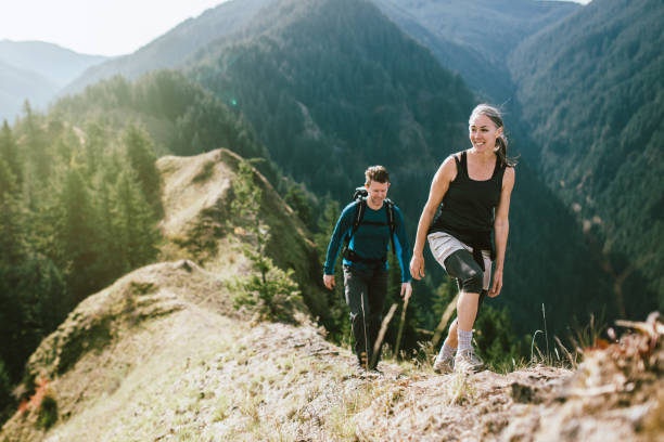 山のハイキングに大人のカップルに適合します。 - climbing women sport mountain ストックフォトと画像