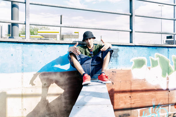istock a rap singer on a concrete beam in a subway with graffiti in the background 675710096