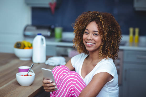 istock Happy young woman using smartphone with food 675711290
