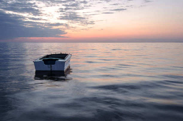 Albion, Mauritius - April 03, 2023: Silhouette of fishermen boat at the beach in the West of Mauritius during sunset.