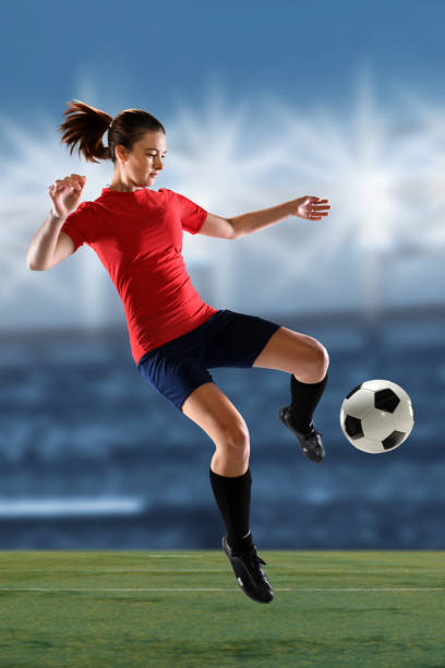istock Female Soccer Player Kicking Ball 675716876