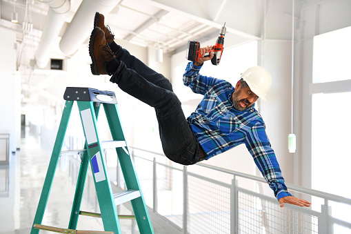 Trabajador hispano cayendo de la escalera photo
