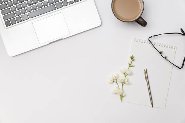 istock working place with blank notebook, branch of flower jasmine, cup 675720566