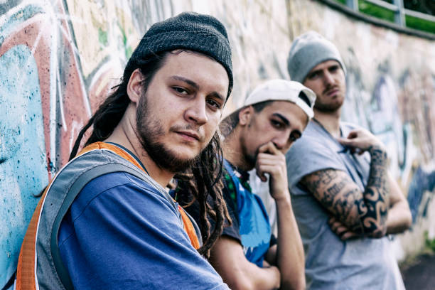 três cantores de rap em um metrô com graffiti em segundo plano - hooligan - fotografias e filmes do acervo