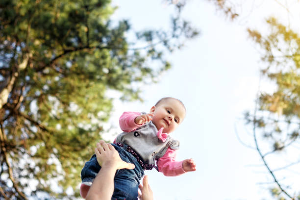 istock Father throws baby in up above him, happy together, spring 675729676