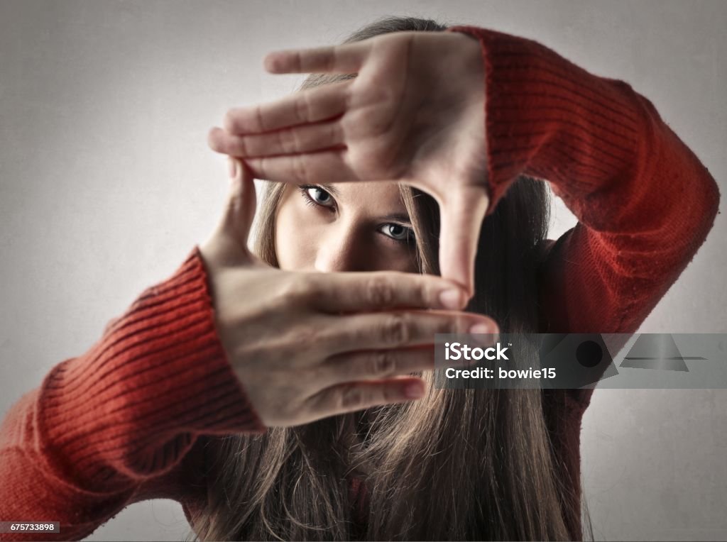 In focus Woman is holding her hand, like a camera Film Director Stock Photo