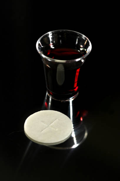 Communion bread and wine on a white surface.