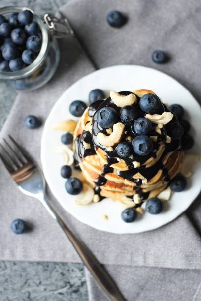 Stack of pancakes with blueberries and chocolate sauce. Top view.