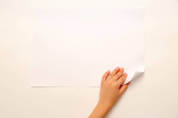 istock Child's hand turning over paper 675741256