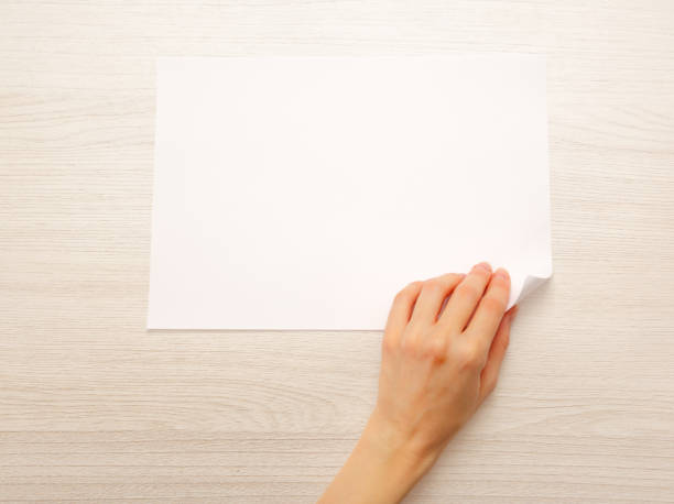 istock Woman's hand turning over paper 675746334