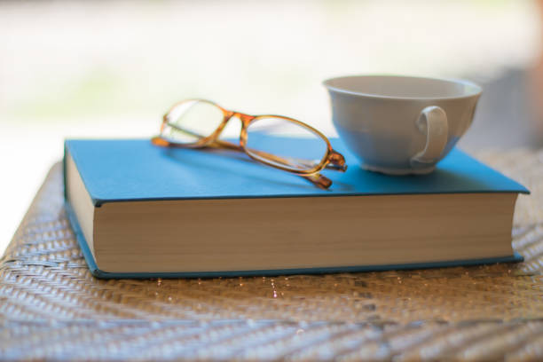 istock Book, cup and eyeglasses on a chair. 675747248