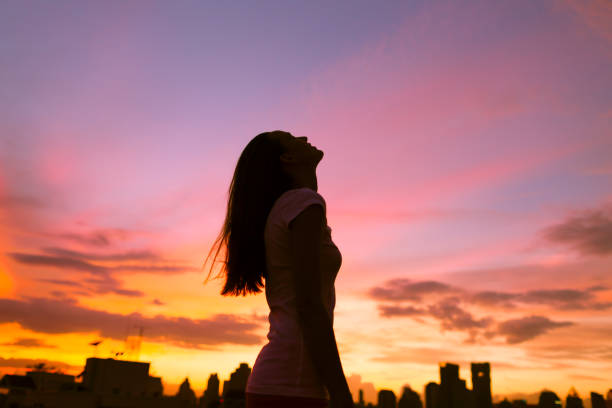 Freedom and stress free concept Happy woman in the city looking up into the sky teenage girls dusk city urban scene stock pictures, royalty-free photos & images