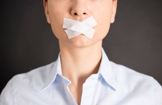 Censorship Young woman with tape on her mouth. censorship stock pictures, royalty-free photos & images