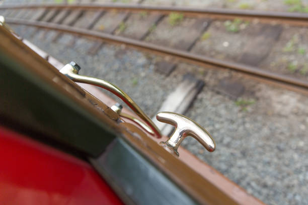 Railway door brass handle with railway line in distance