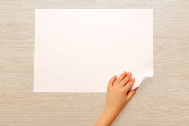 istock Child's hand turning over paper 675764366