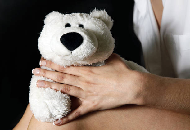 istock Toy white bear and female hand 675764468