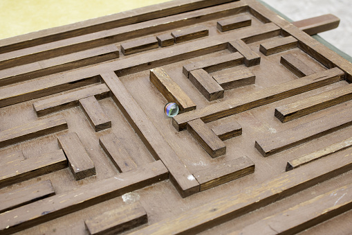 Labyrinth with marble on wooden table, games and fun