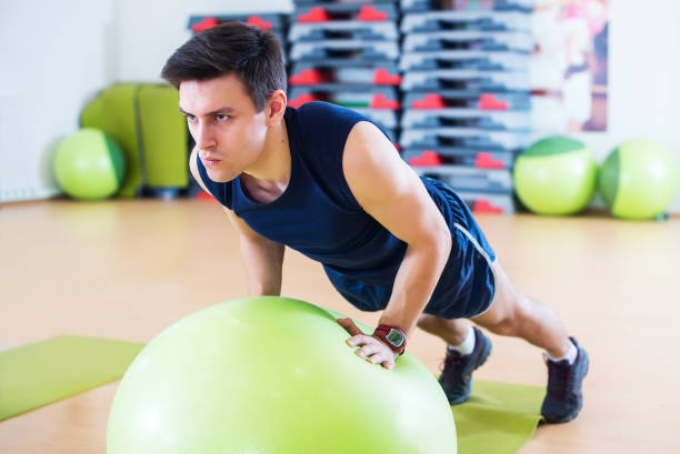 istock Fit man exercising with  ball workout out arms Exercise training triceps and biceps doing push ups. 675767302