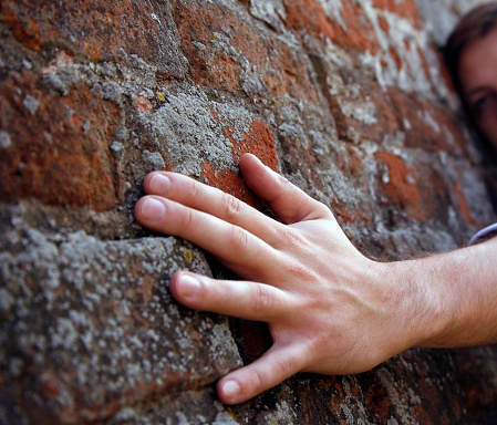 Hand of the man on a background of a brick wall