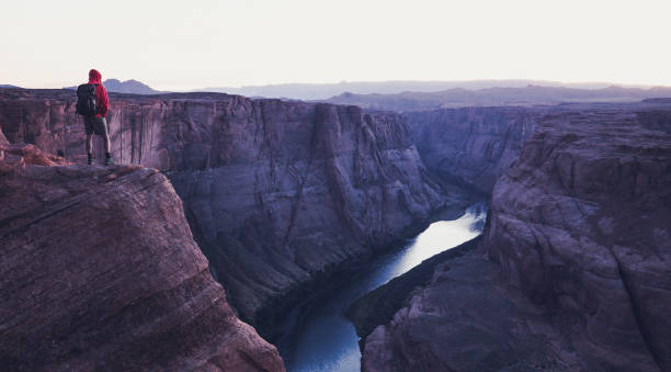 미국 애리조나 주 황혼의 호스슈 벤드를 내려다보는 남성 등산객 - glen canyon 뉴스 사진 이미지