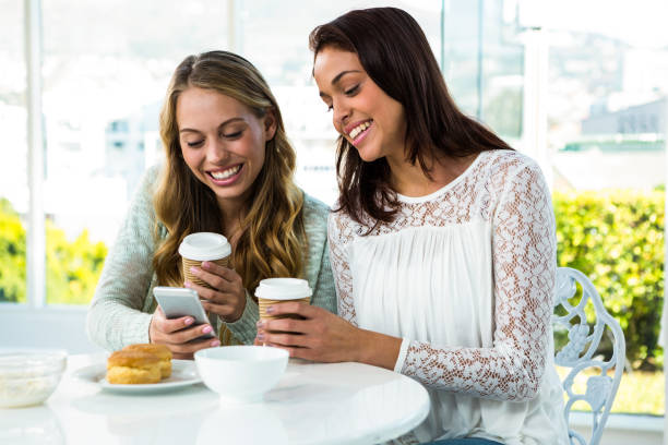 istock two girls use a phone 675777620
