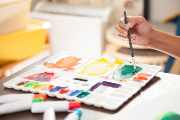 istock a child's hand with paint and palette and brush 675783422