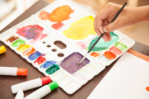 istock a child's hand with paint and palette and brush 675785268