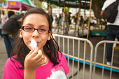 Young girl eating cotton candy at the carnival