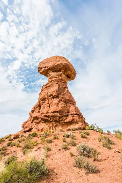 Tall red balanced rock in Arches National Park in canyons