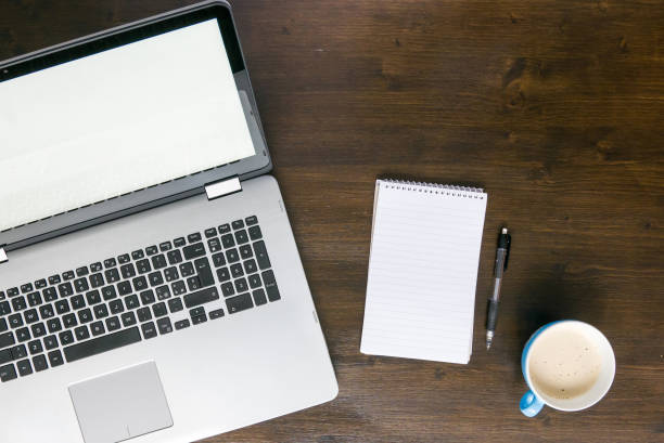 istock laptop on desk with coffee and notepad top view 675790646