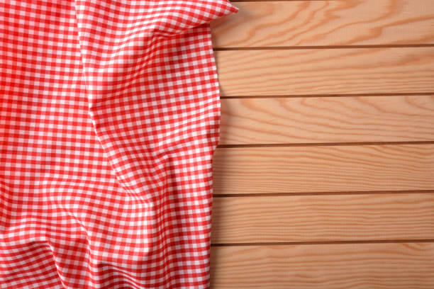 istock Red and white checkered fabric on wood table top 675790990