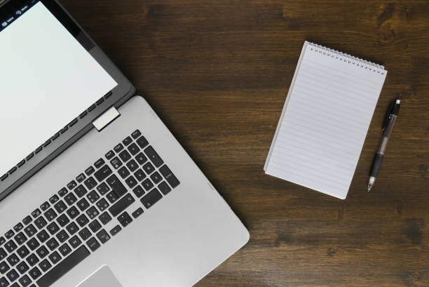 istock Top view of laptop and notepad on desk 675794002
