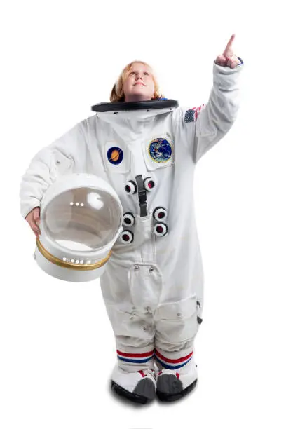 This is a photo of the young astronaut boy holding a space helmet pointing up towards the sky. The background is a pure white