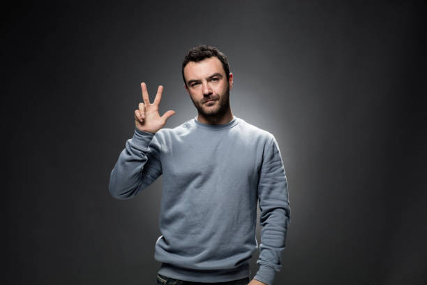istock Young Man Showing Number Three with Fingers. 675800358