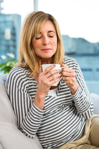 istock Woman holding cup on sofa 675806046