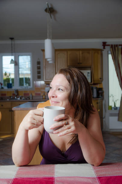 istock Woman relaxing at dining table with a coffee 675814972