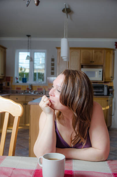 istock Woman relaxing at dining table with a coffee 675815112