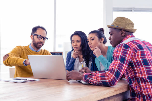 istock Serious businessman with colleagues discussing on laptop 675817382